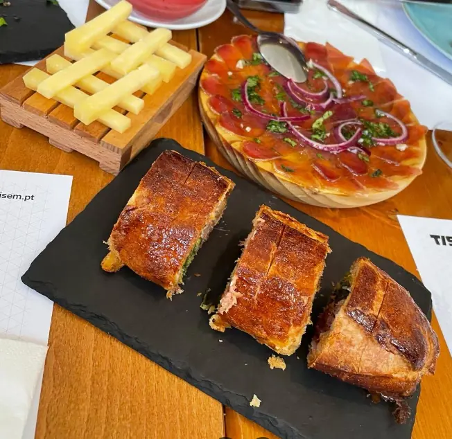 Tábua com queijo em palitos, carnes fumadas e pão